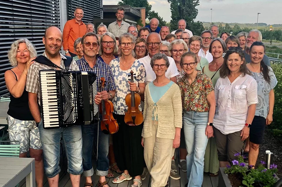På bildet ser du medlemmer av Solheimkoret, dirigent Inger-Pernille Stramrud og folkemusikerne Stein Skogen Grytting og Olav Sæta som medvirket på årets midtsommerkonsert.